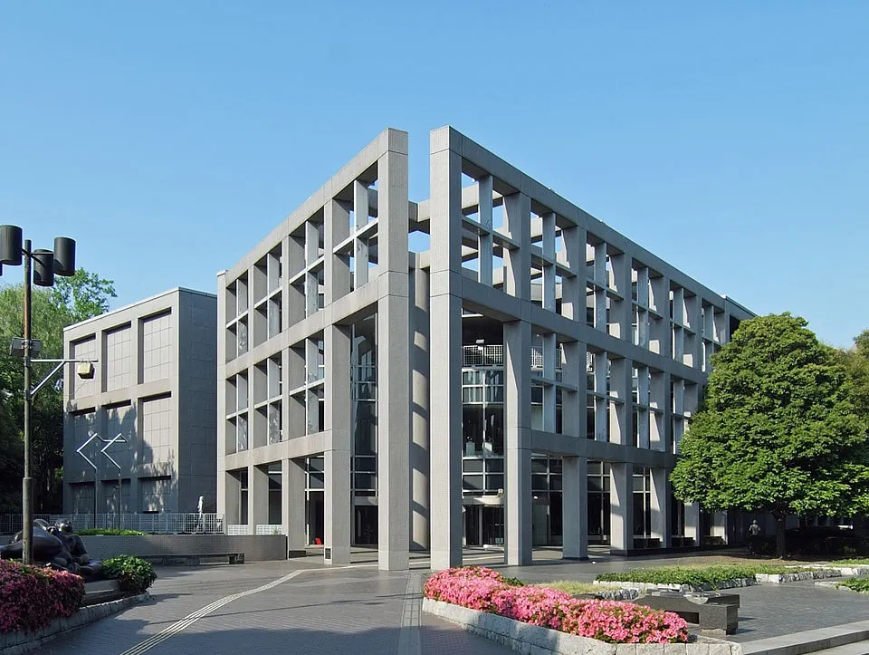 埼玉県立近代美術館の外観。格子状の柱が特徴的な建物と前庭の花壇や通路が見える